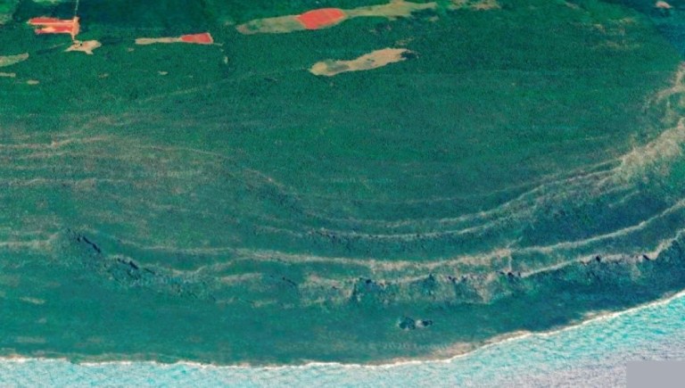 Fig. 2. Terrazas emergidas al SE de Cabo Cruz, donde se observan las bocas de cavernas en las paredes de las terrazas, solapas derrumbadas y el Hoyo Morlote.
