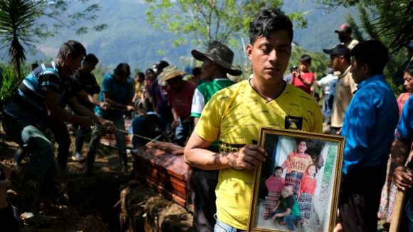 Un padre con la foto de su esposa e hijos fallecidos en un deslizamiento de tierra por el huracán 